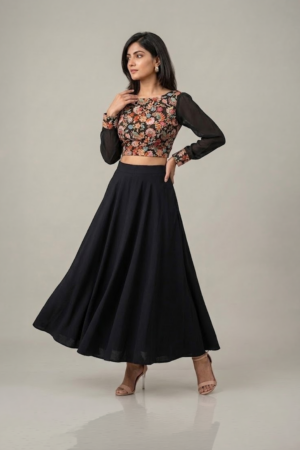Woman wearing a black floral embroidered dress with sheer sleeves and a flowing flared skirt
