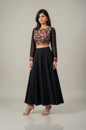 Woman wearing a black floral embroidered dress with sheer sleeves and a flowing flared skirt