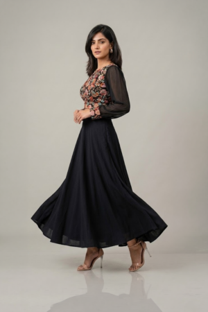 Woman wearing a black floral embroidered dress with sheer sleeves and a flowing flared skirt