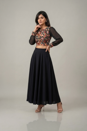 Woman wearing a black floral embroidered dress with sheer sleeves and a flowing flared skirt