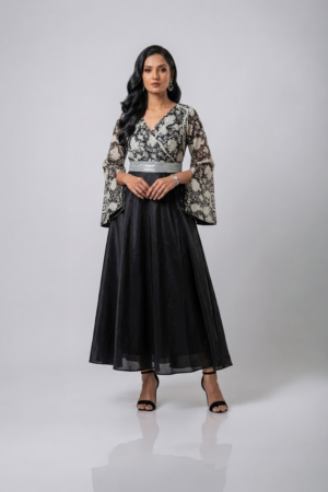Woman wearing a black gown with a monochrome printed wrap bodice, flared kimono sleeves and a flowing maxi skirt