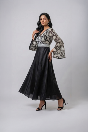 Woman wearing a black gown with a monochrome printed wrap bodice, flared kimono sleeves and a flowing maxi skirt