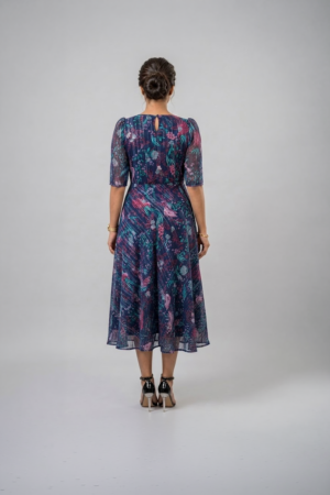Woman wearing a navy blue floral midi dress with a square neckline, puff sleeves and an A-line silhouette