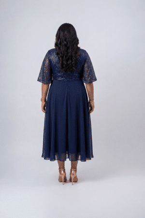 Woman wearing a midnight navy sequin gown with a wrap V-neckline, elbow-length sleeves and a flowing A-line skirt