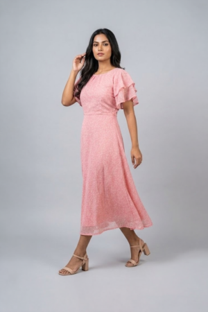 Woman wearing a soft pink midi dress with layered flutter sleeves and a flowing A-line silhouette