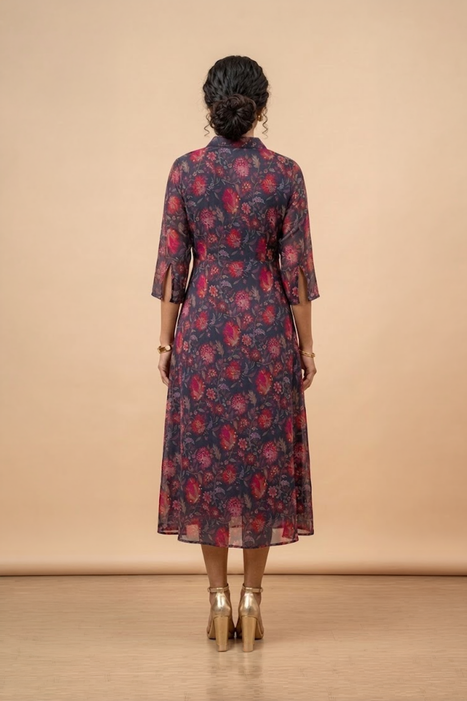 Woman wearing a blue floral shirt dress with three-quarter sleeves and a flared midi silhouette