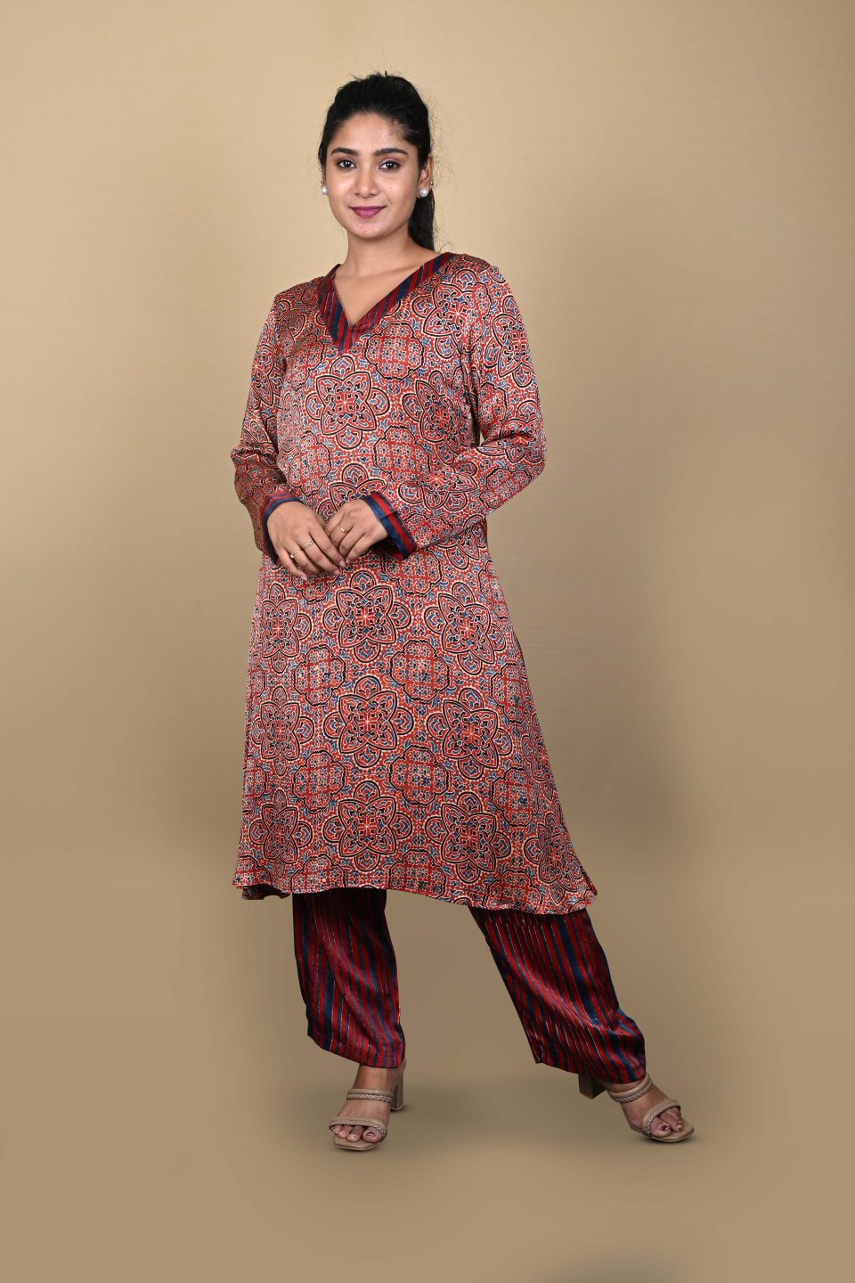 Front view of rust Ajrakh print kurta with striped pants