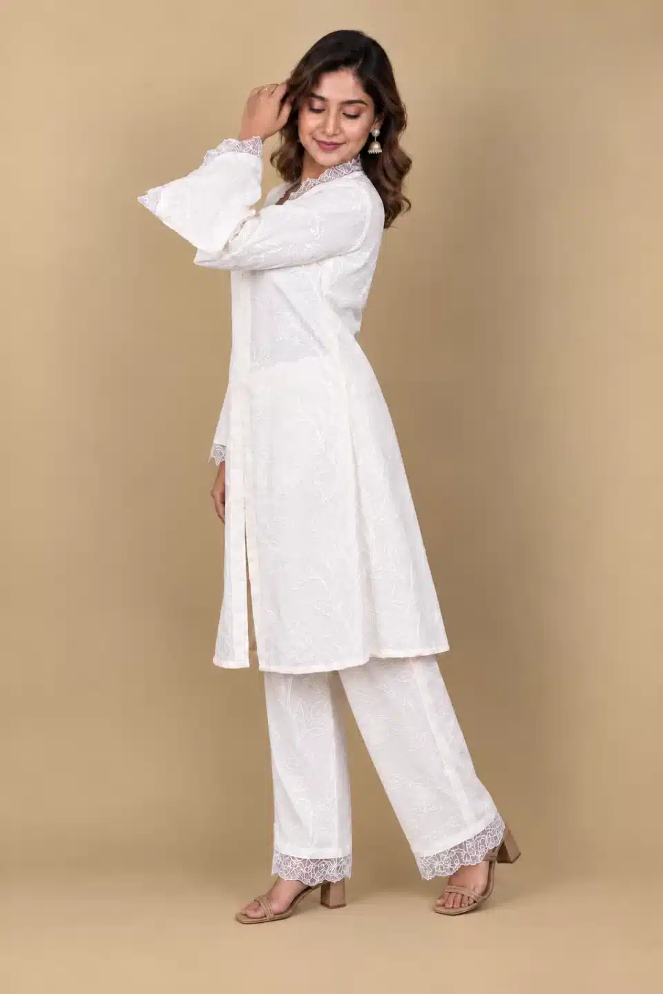 Three-quarter side view of ivory floral kurta set showing flared lace sleeves and matching full-length trousers
