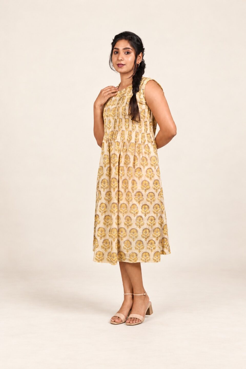 Yellow and beige Ajrakh cotton sleeveless dress, three-quarter front view with nude ankle-strap sandals