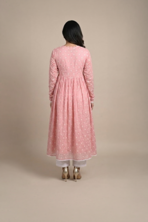 Woman wearing a dusty pink embroidered Anarkali with a scalloped V-neckline, long sleeves and white pants