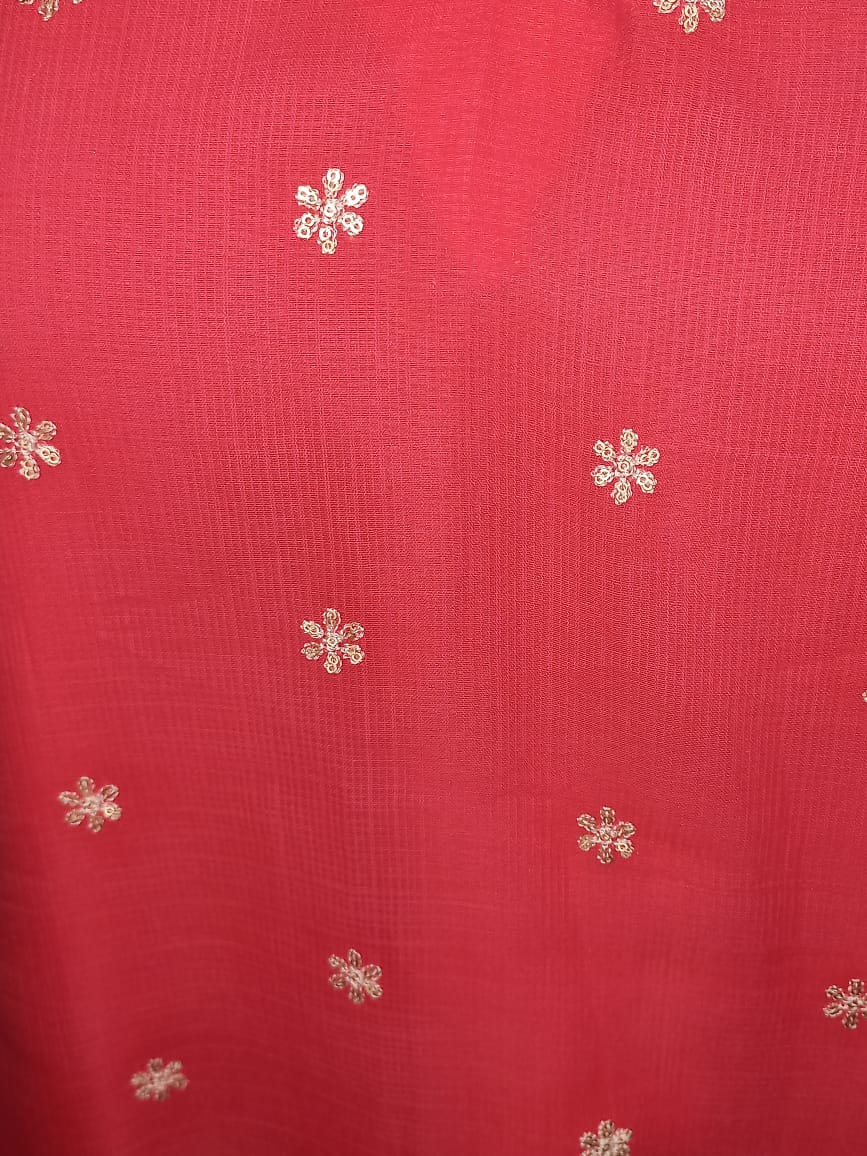 “Woman wearing a pink chikankari cotton kurta dress with white floral embroidery, V-notch neckline, and 3/4 sleeves standing against a beige background.”