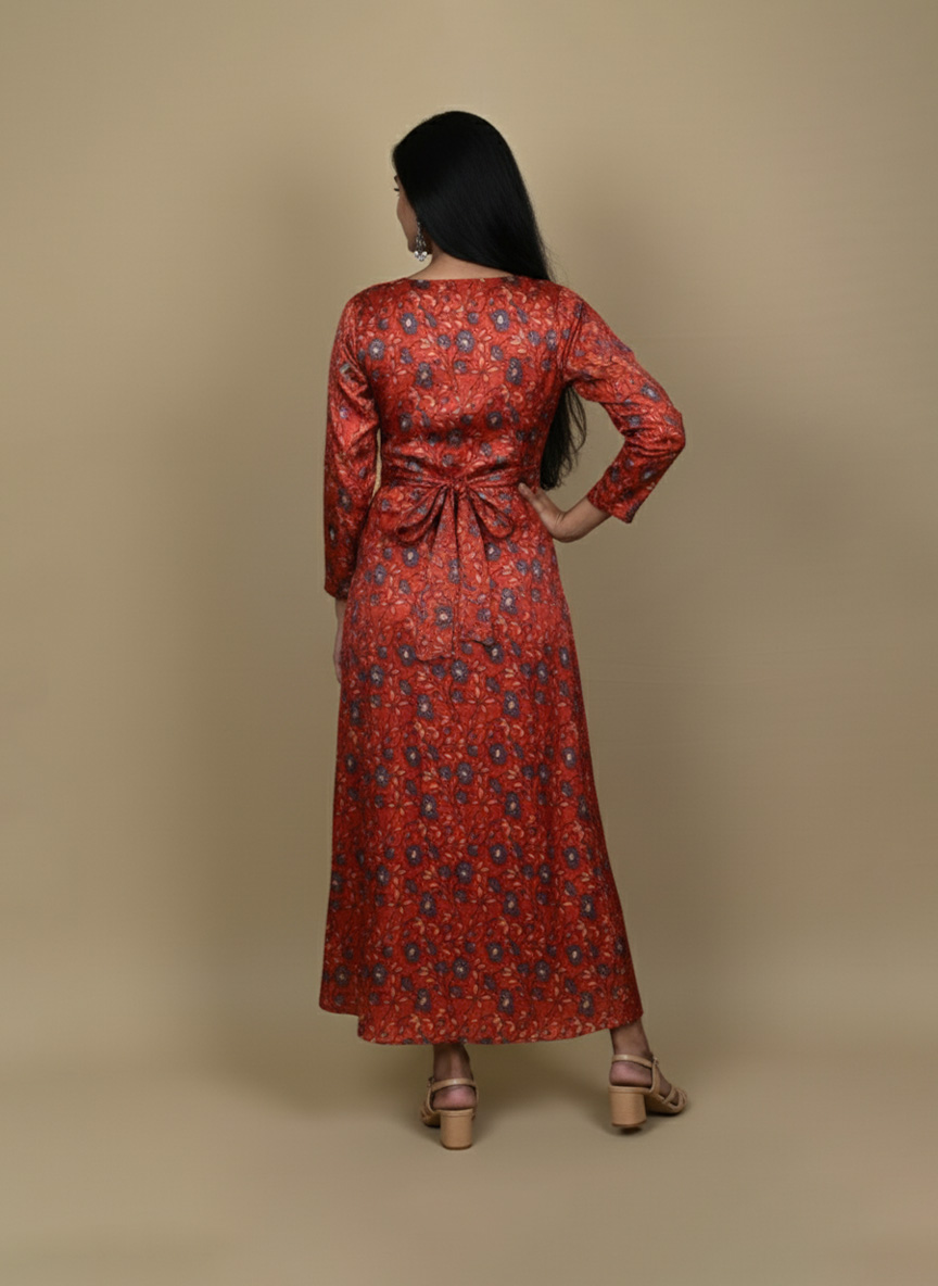"Woman wearing a red floral printed long A-line dress with full sleeves, posing against a beige background"