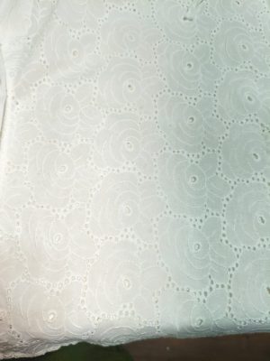 woman wearing a white cotton eyelet shirt dress with three quarter sleeves and waist tie