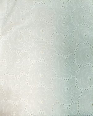 woman wearing a white cotton eyelet shirt dress with three quarter sleeves and waist tie