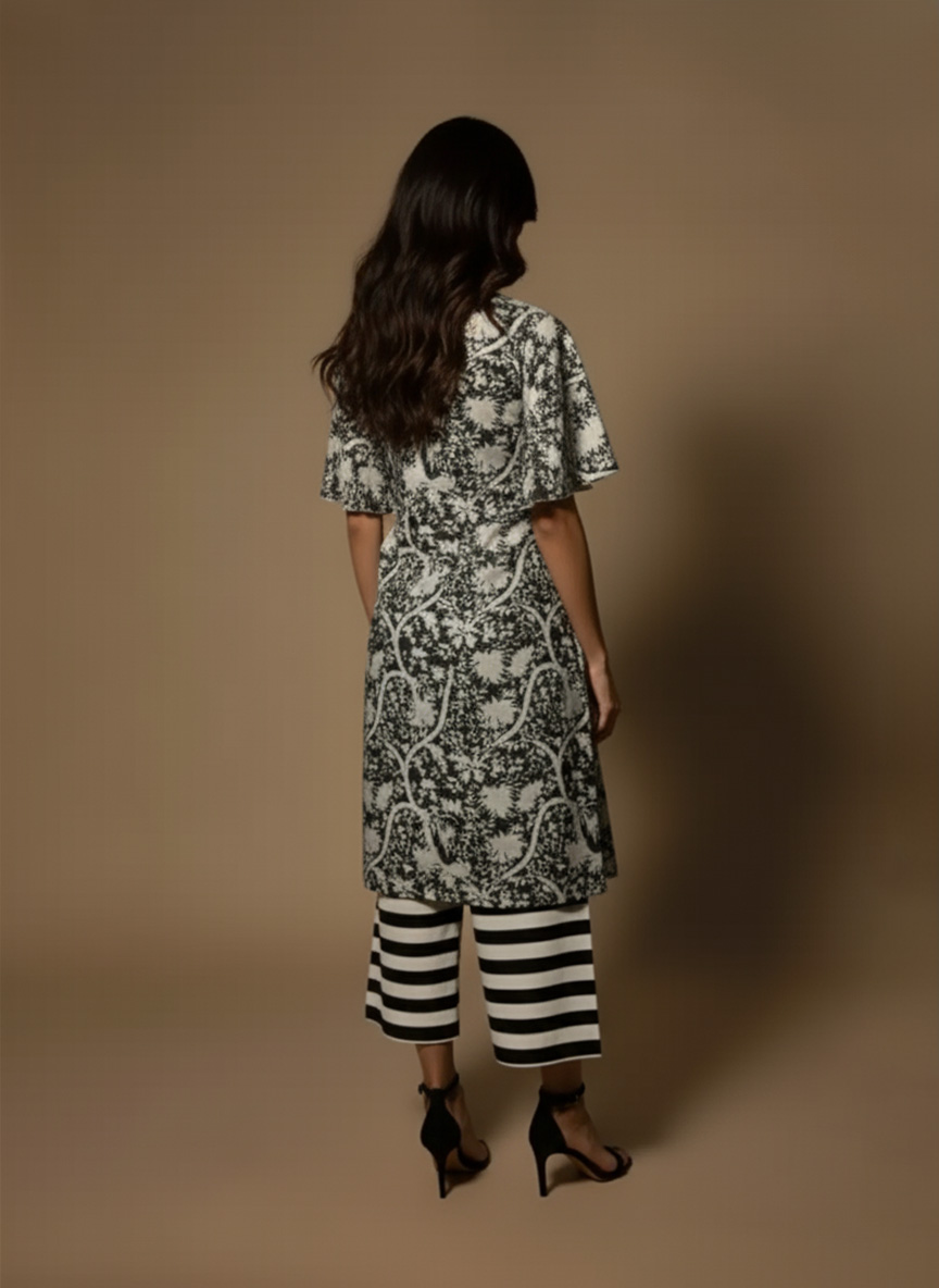 Model wearing a black and white printed cotton kurta set with sleeveless V-neck kurta and striped palazzo pants from Ivory by Radhika.