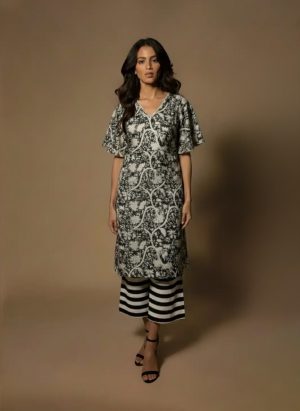 Model wearing a black and white printed cotton kurta set with sleeveless V-neck kurta and striped palazzo pants from Ivory by Radhika.