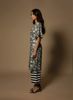 Model wearing a black and white printed cotton kurta set with sleeveless V-neck kurta and striped palazzo pants from Ivory by Radhika.