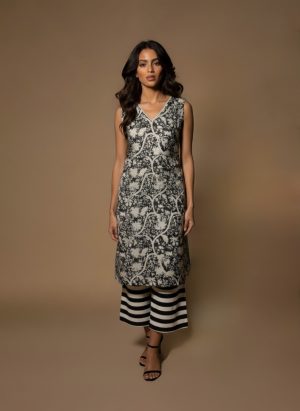 Model wearing a black and white printed cotton kurta set with sleeveless V-neck kurta and striped palazzo pants from Ivory by Radhika.