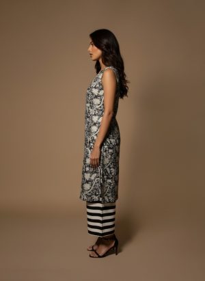 Model wearing a black and white printed cotton kurta set with sleeveless V-neck kurta and striped palazzo pants from Ivory by Radhika.