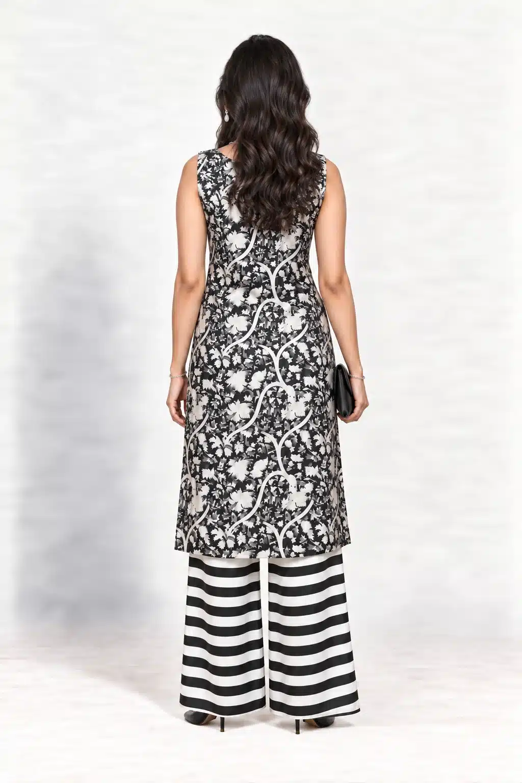 Black and white botanical-print sleeveless kurta with striped palazzo trousers, full-length back view