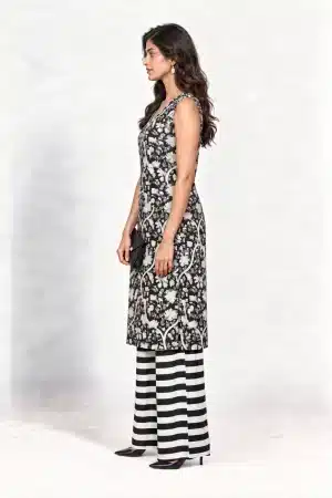 Black and white botanical-print sleeveless kurta with striped palazzo trousers, full-length side view