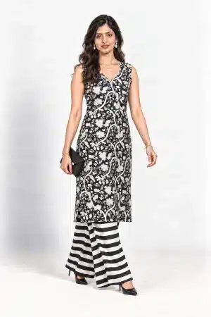 Black and white botanical-print sleeveless kurta with striped palazzo trousers, walking pose