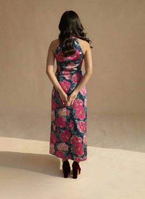 Model wearing a navy blue floral maxi dress with a halter neckline and bold pink floral prints from Ivory by Radhika.