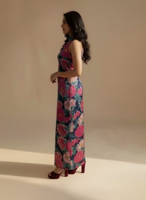Model wearing a navy blue floral maxi dress with a halter neckline and bold pink floral prints from Ivory by Radhika.