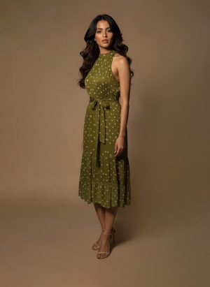 Model wearing an olive green halter neck midi dress with polka dots and a satin waist tie from Ivory by Radhika.