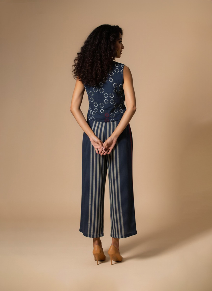 Model wearing an Indigo Handloom Co-ord Set featuring a sleeveless floral-printed vest and striped long skirt, handcrafted in cotton from Ivory by Radhika.
