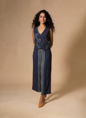 Model wearing an Indigo Handloom Co-ord Set featuring a sleeveless floral-printed vest and striped long skirt, handcrafted in cotton from Ivory by Radhika.
