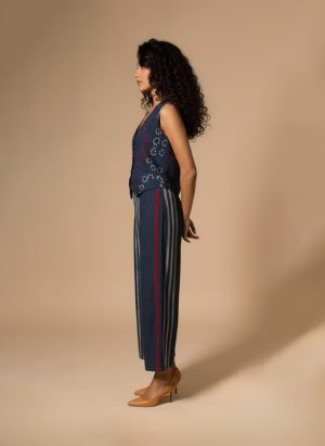 Model wearing an Indigo Handloom Co-ord Set featuring a sleeveless floral-printed vest and striped long skirt, handcrafted in cotton from Ivory by Radhika.