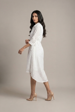 woman wearing a white cotton eyelet shirt dress with three quarter sleeves and waist tie