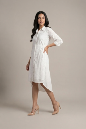 woman wearing a white cotton eyelet shirt dress with three quarter sleeves and waist tie
