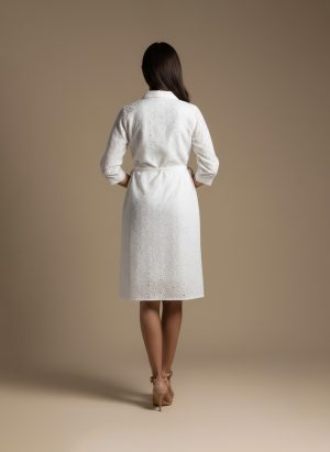 woman wearing a white cotton eyelet shirt dress with three quarter sleeves and waist tie