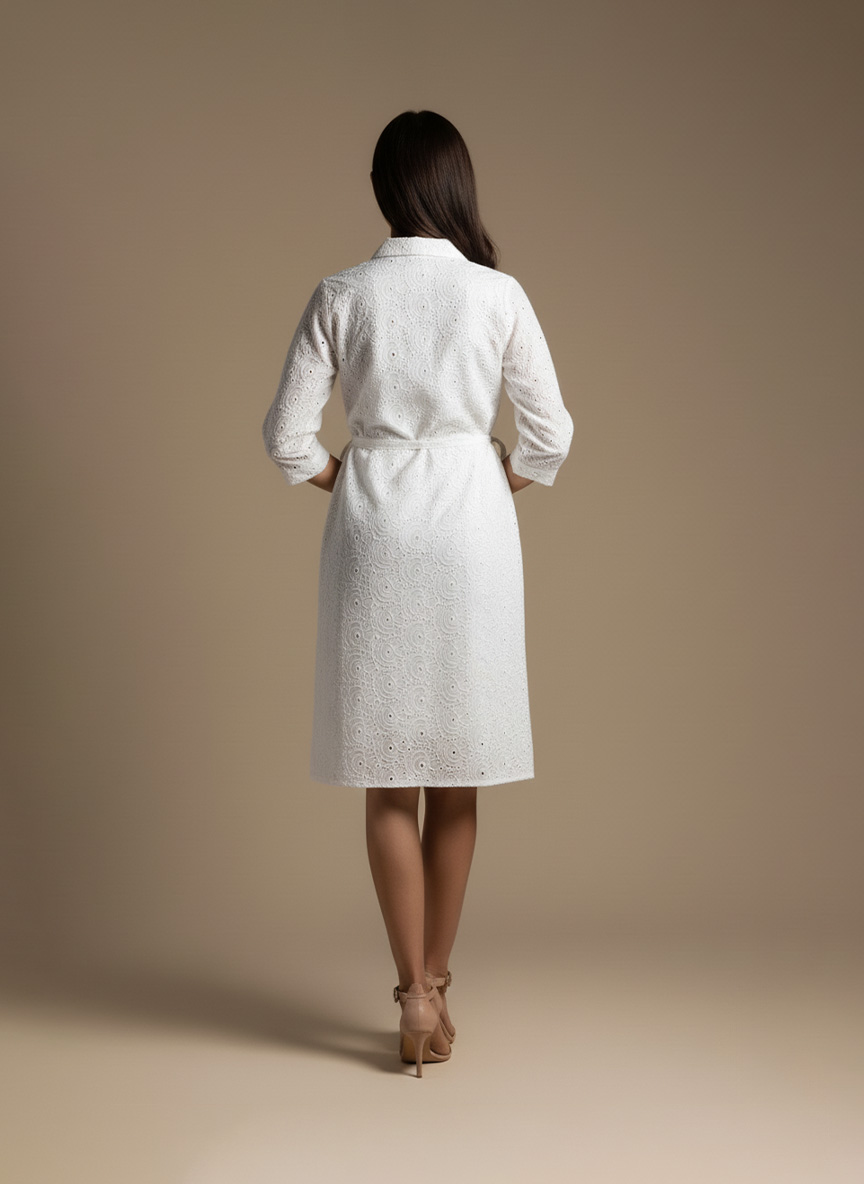 woman wearing a white cotton eyelet shirt dress with three quarter sleeves and waist tie