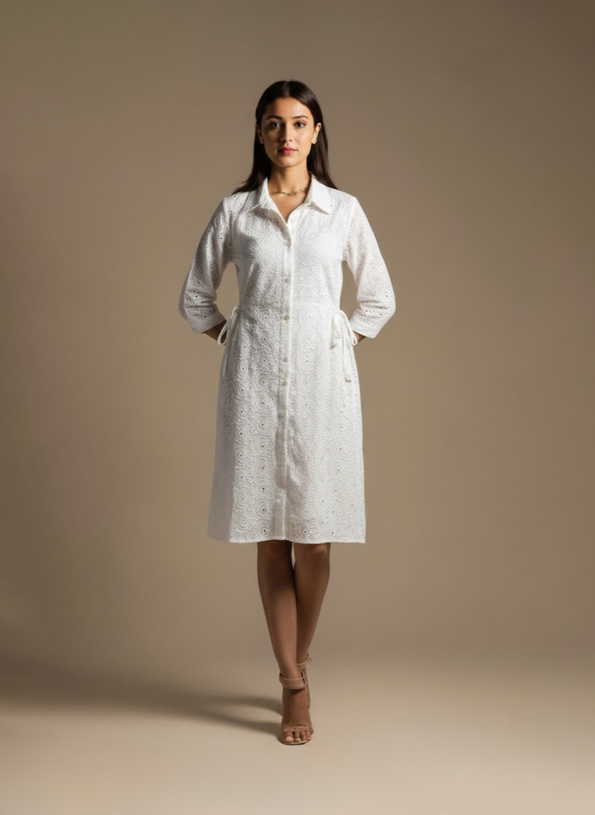 woman wearing a white cotton eyelet shirt dress with three quarter sleeves and waist tie