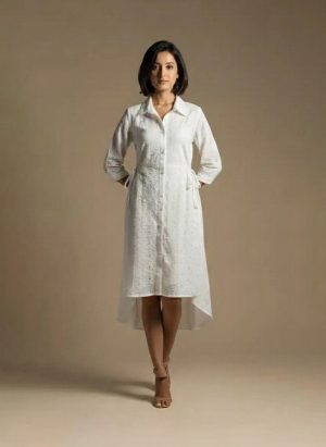 woman wearing a white cotton eyelet shirt dress with three quarter sleeves and waist tie