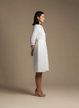 woman wearing a white cotton eyelet shirt dress with three quarter sleeves and waist tie