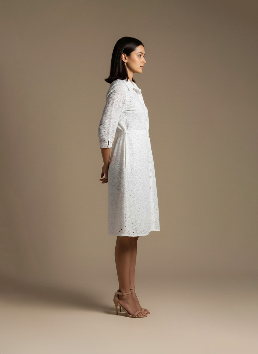 woman wearing a white cotton eyelet shirt dress with three quarter sleeves and waist tie