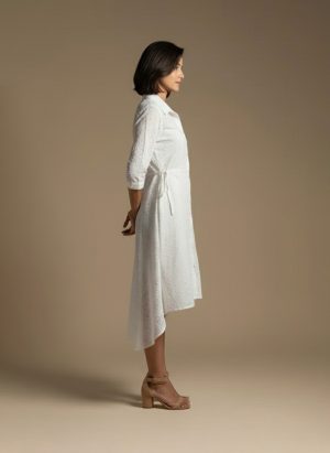 woman wearing a white cotton eyelet shirt dress with three quarter sleeves and waist tie