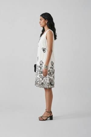 Elegant white sleeveless A-line dress with black floral embroidery and scalloped hem, perfect for summer brunch and resort wear.