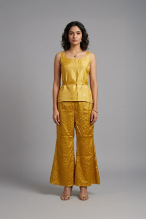 Woman wearing mustard silk co-ord set with sleeveless top and flared pants
