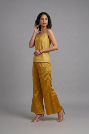 Woman wearing mustard silk co-ord set with sleeveless top and flared pants