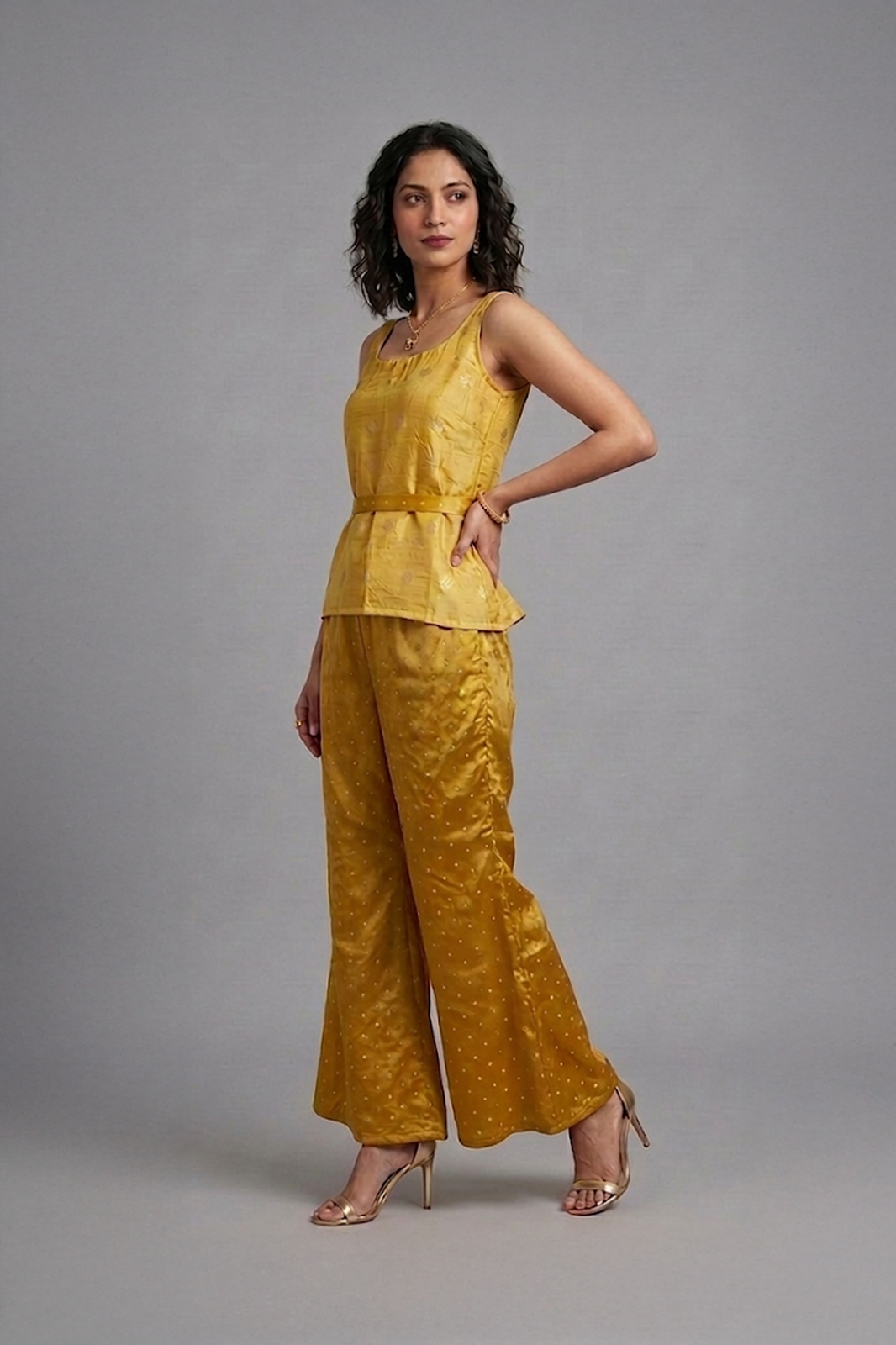 Woman wearing mustard silk co-ord set with sleeveless top and flared pants