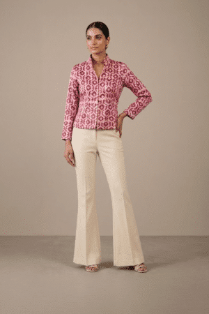 Model wearing pink and ivory geometric-print short jacket with front buttons and full sleeves, front view