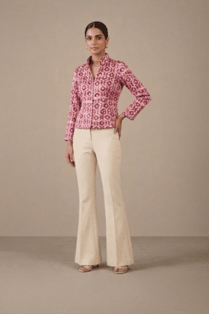 Full-length front view of model wearing pink geometric-print short jacket with ivory trousers