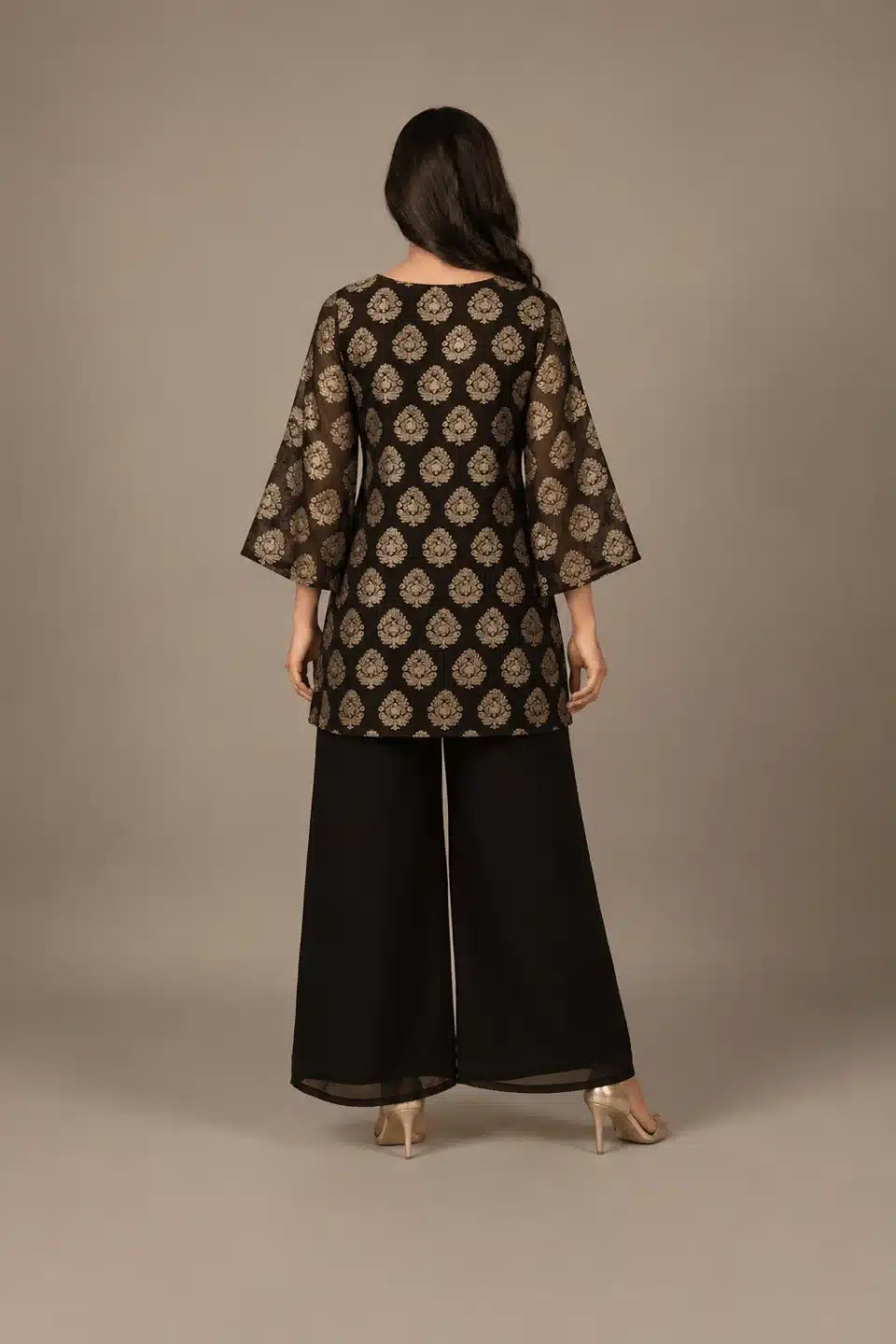 Black and gold floral-print kurta with flared sleeves and black palazzo pants, full-length back view.
