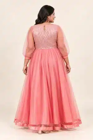 Back view of coral pink shimmering tulle gown on a plus-size model