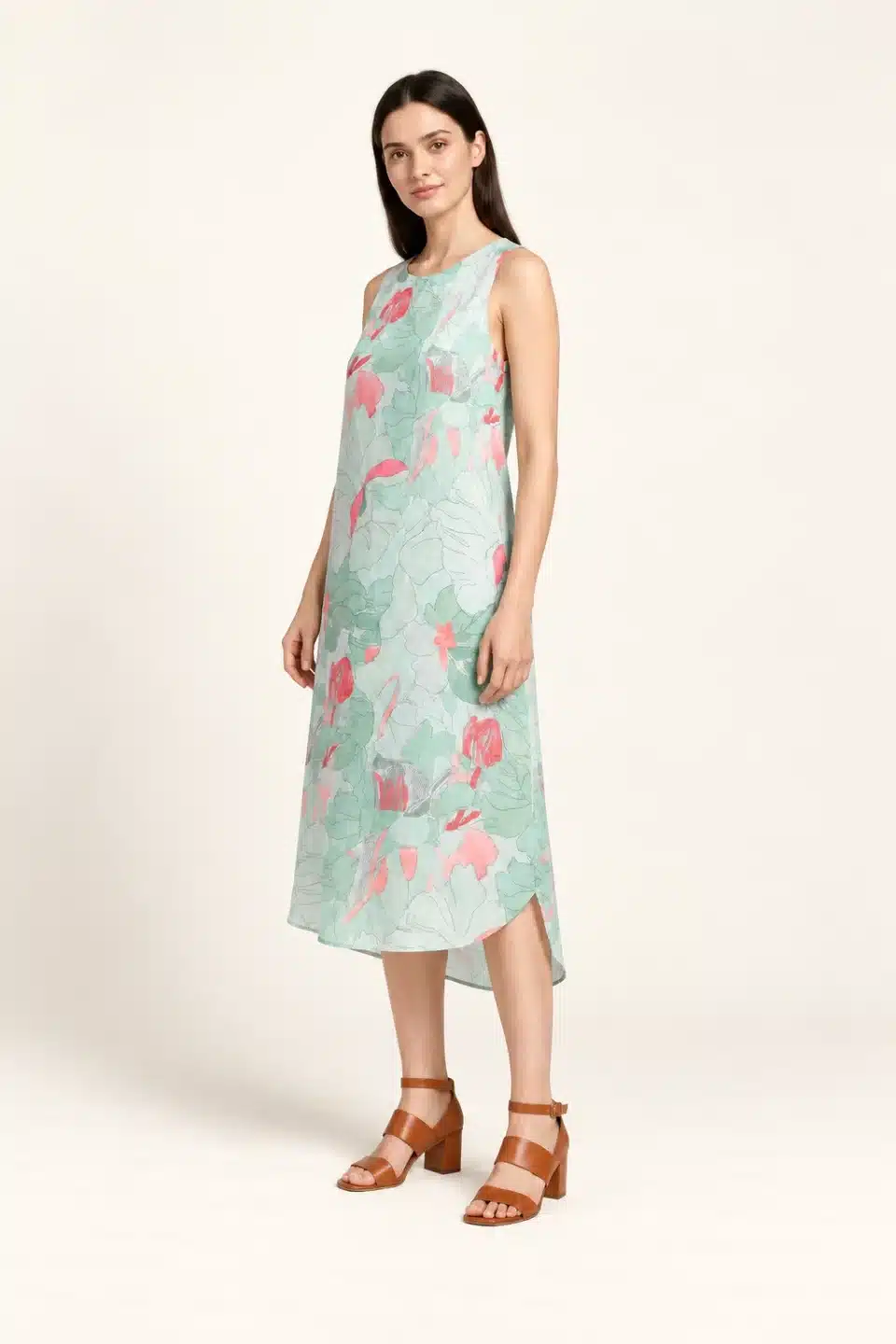 Three-quarter view of mint floral sleeveless linen dress with curved hem
